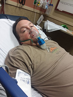 Dan in the hospital waring a oxygen mask