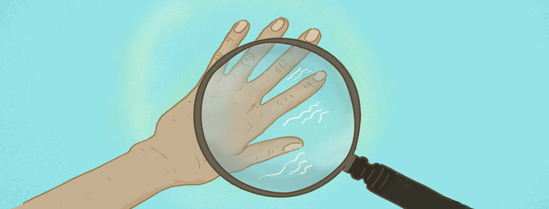 A magnifying glass hones in on a hand with a tremor.