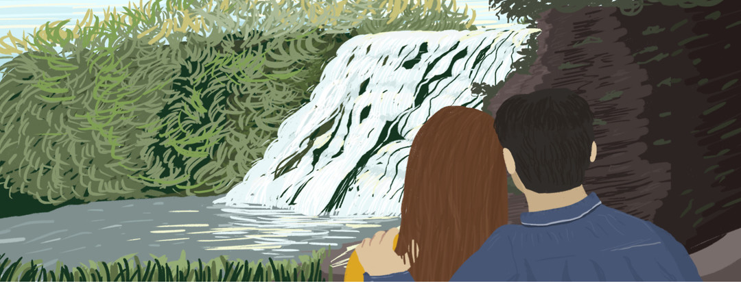 A couple wraps their arms around each other while watching the Ithaca waterfalls.