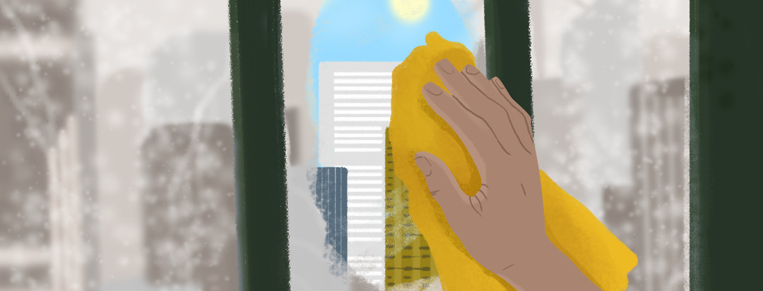 A person's hand wipes away a fogged window to reveal a patch of sunlight gleaming through city buildings.