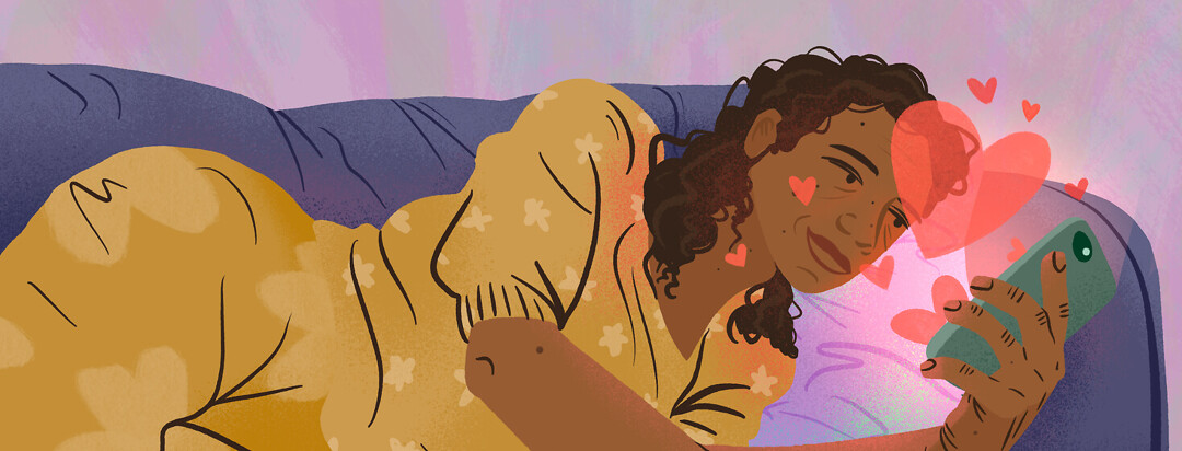 Black woman laying on couch smiles at her phone as hearts emerge from the screen