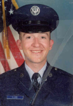 Man Pictured in military uniform in front of American flag