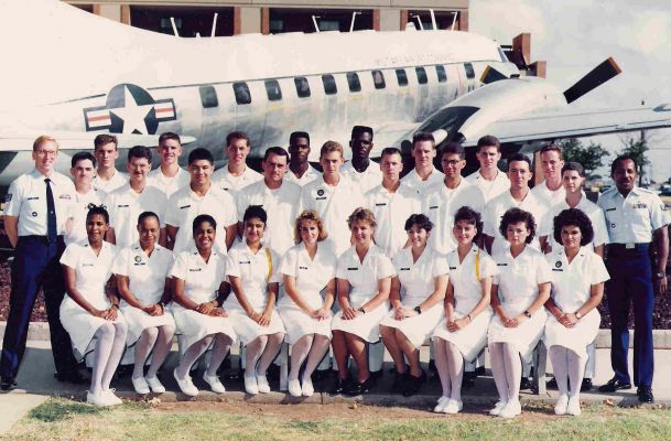 group military photo of everyone dressed in white in front of military plane 