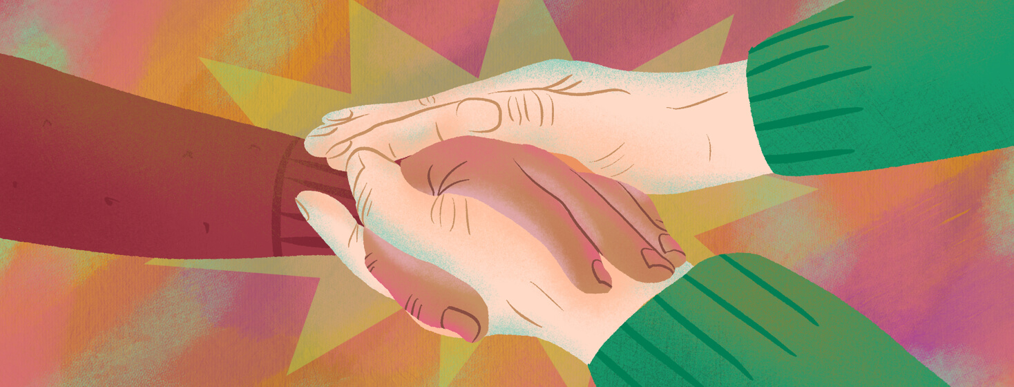 A person grasps the hand of a loved one with both of their hands in a gesture of support