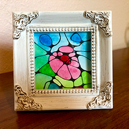 A framed piece of geometric floral artwork.